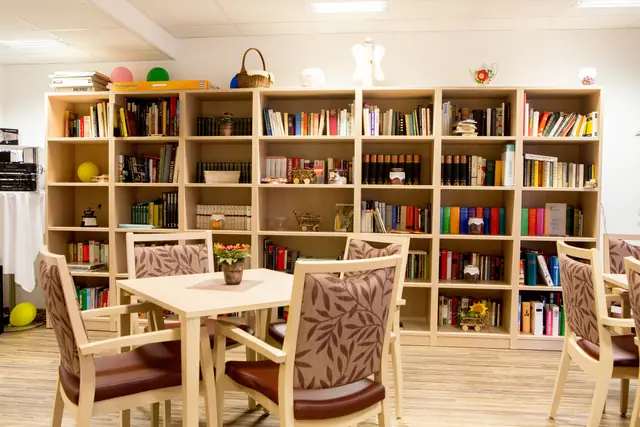 Aufenthaltsraum mit Bücherregal und Tischen