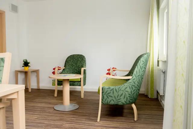 Ruhige Sitzecke mit grünen Sesseln am Fenster